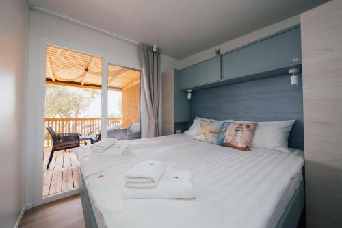 sypialnia z dużym łóżkiem z ręcznikami w obiekcie MOBILE HOMES SELCE - Lighthouse w mieście Selce