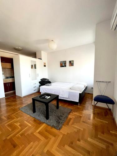 a bedroom with a bed and a table in it at Stan na dan u centru, Inđija in Inđija