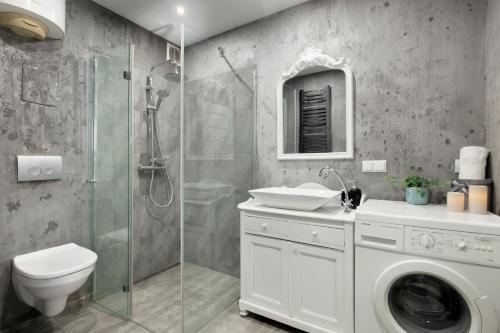 uma casa de banho com um lavatório e um chuveiro. em Elite Apartments Boho Old Town em Gdansk