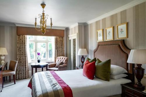 Habitación de hotel con cama y lámpara de araña. en Audleys Wood Hotel, Basingstoke en Basingstoke