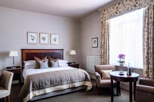 a bedroom with a bed and a large window at Audleys Wood Hotel, Basingstoke in Basingstoke