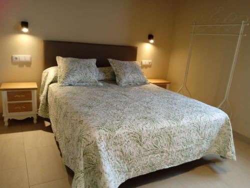 a bedroom with a large bed and two night stands at O Lar do Alecrín in Friol