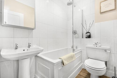 La salle de bains blanche est pourvue de toilettes et d'un lavabo. dans l'établissement Lovely large 1 bed renovated flat w balcony & 600MB WiFi, à Londres