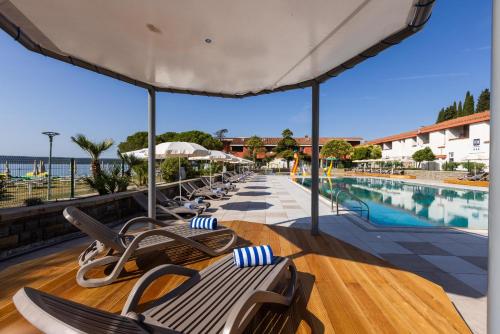 a row of lounge chairs and a swimming pool at Hotel Vile Park in Portorož