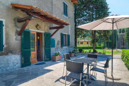 une terrasse avec un parasol, une table et des chaises dans l'établissement B & B - L'aia dì Trippa all'Aria, à Borgo San Lorenzo