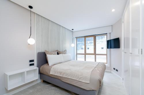 a white bedroom with a bed and a window at PREMIUM HOME EL CORTE INGLES-parking in Vigo