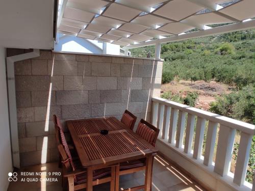 a wooden table and chairs on a balcony at Apartments Mateljak in Gradac