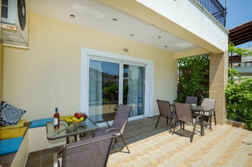 a patio with a table and chairs and a dining room at Gold n Blu Petalidi in Petalidhion