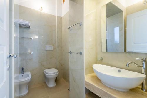 a bathroom with a sink and a toilet and a mirror at TENUTA DOROLIVO in Otranto