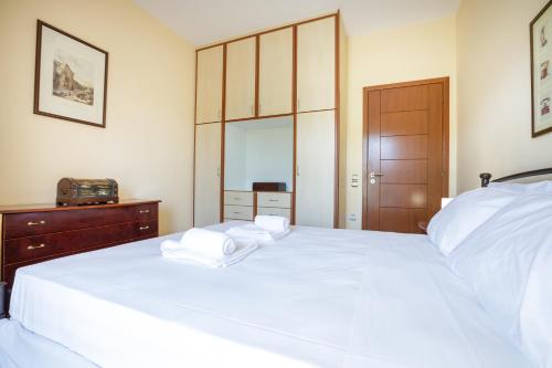 a bedroom with a large white bed with towels on it at Gold n Blu Petalidi in Petalidhion