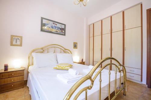 a bedroom with a white bed and a wooden cabinet at Gold n Blu Petalidi in Petalidhion