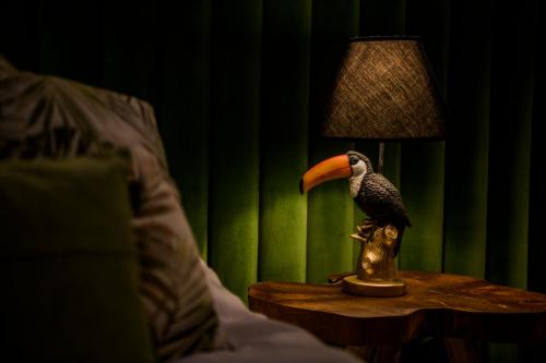 a bird sitting on a table next to a lamp at Aqua Your Stay in Sasino