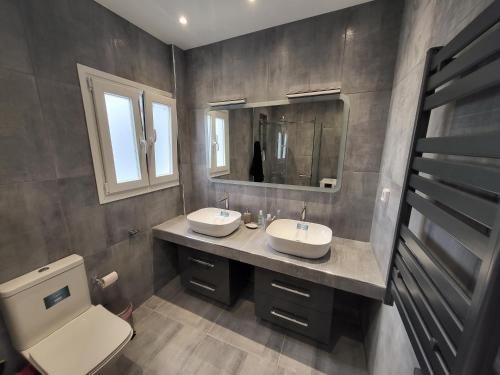 een badkamer met 2 wastafels en een toilet bij Maria's Maisonette in Athene