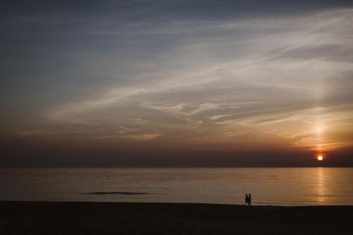 two people standing on the beach at sunset at KD 883 - Vakantiepark Kijkduin in The Hague