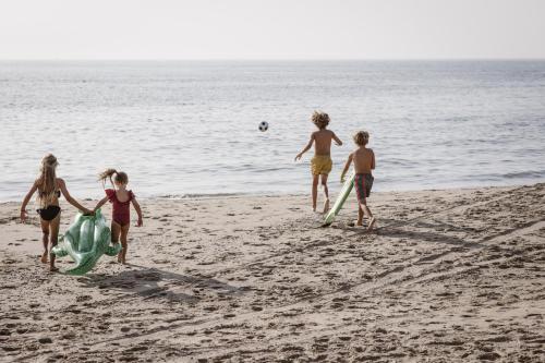 a group of children playing on the beach at KD 883 - Vakantiepark Kijkduin in The Hague
