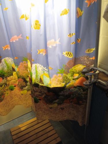 a shower curtain with an aquarium with fish in it at John's Home, δωμάτια σε οικογενειακό Διαμέρισμα, Συγκατοίκηση in Volos