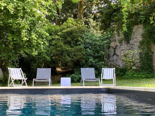 Calignac的住宿－Coeur de Calignac，游泳池旁的三把椅子