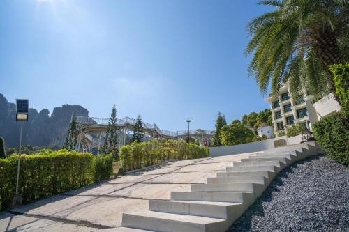 a sidewalk with steps and a palm tree and a building at Heaven View Krabi SHA in Ao Nam Mao