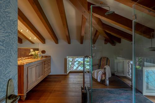 a bathroom with a glass shower and a wooden ceiling at Villa delle Palme in Gargnano