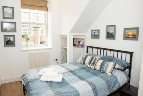 a bedroom with a blue and white bed and a window at Parade School Guest Rooms in Berwick-Upon-Tweed