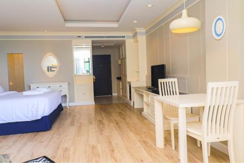a bedroom with a bed and a desk and a table at Heaven View Krabi SHA in Ao Nam Mao