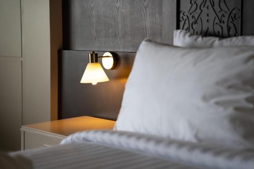 a bed with a white pillow and a lamp at Heaven View Krabi SHA in Ao Nam Mao