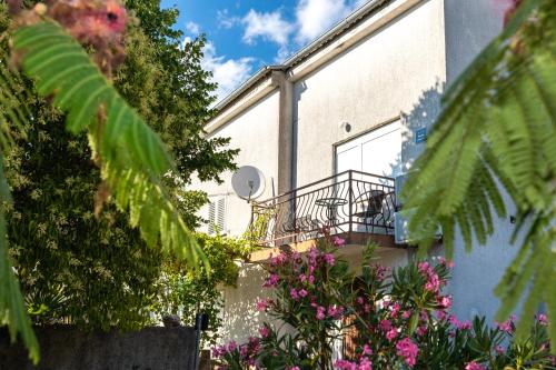 a building with a balcony with pink flowers at House Lora in Risika