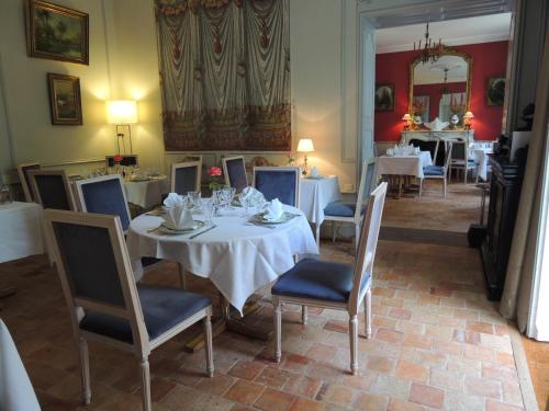 a dining room with a white table and chairs at Le Domaine de Mestré, The Originals Relais in Fontevraud-l'Abbaye