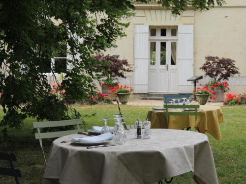 a table with a white table cloth on it in a yard at Le Domaine de Mestré, The Originals Relais in Fontevraud-l'Abbaye