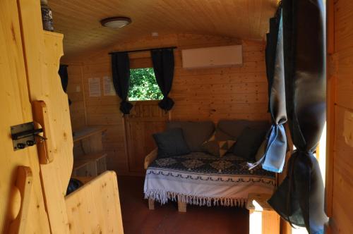a small room with a couch in a log cabin at LA MAGNANERIE in Grillon