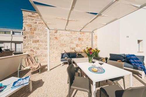 a patio with a table and chairs and a brick wall at HelloApulia - La Terrazza di Don Nino in Polignano a Mare