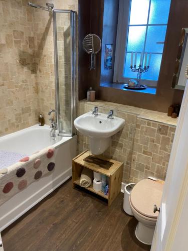a bathroom with a sink and a tub and a toilet at Great rooms in an uber cool flat! London Bridge in London