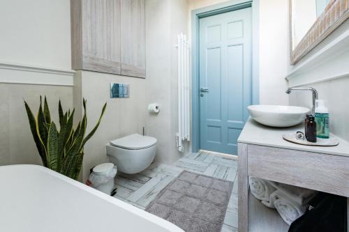 a bathroom with a toilet and a sink and a tub at Aqua Your Stay in Sasino