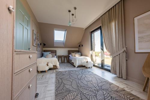 a bedroom with two beds and a large window at Aqua Your Stay in Sasino