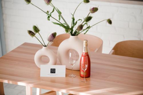 a table with two white vases and a bottle of champagne at Aqua Your Stay in Sasino