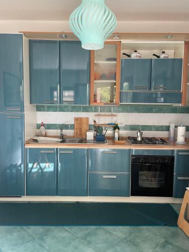 een keuken met blauwe kasten en een kroonluchter bij VillApulia in Brindisi