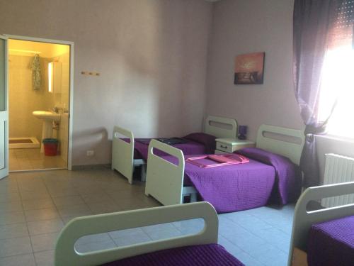 a room with two beds and purple sheets at Casa Per Ferie Raggio Di Sole in Ceriale