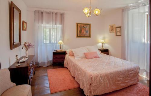 a bedroom with a bed and a desk and two windows at Awesome Home In Brcena De Ebro With Kitchen in Bárcena de Ebro