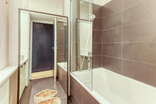 een badkamer met een bad en een glazen douche bij Gorgeous 2 Bdrs Flat in a Prime Location - Opera in Parijs
