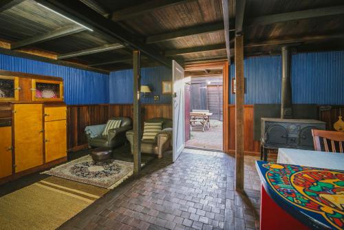 Hoddy WellにあるThe Dairy - 2 Story Historic accommodation with Mod Consのソファとストーブのあるリビングルーム