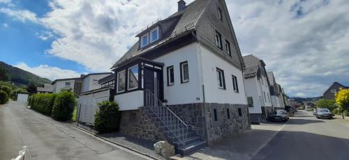 ein weißes und schwarzes Gebäude an der Straßenseite in der Unterkunft Landhaus Augenblicke Olsberg in Olsberg
