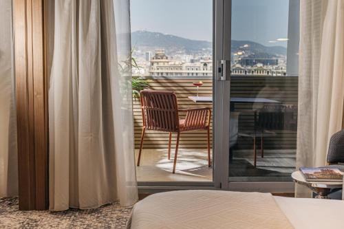 a room with a balcony with a table and a chair at InterContinental Barcelona by IHG in Barcelona