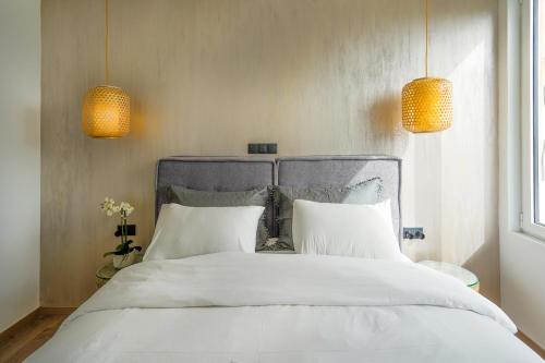 uma cama com duas almofadas brancas e duas luzes em Stylish Living-Parthenon em Atenas