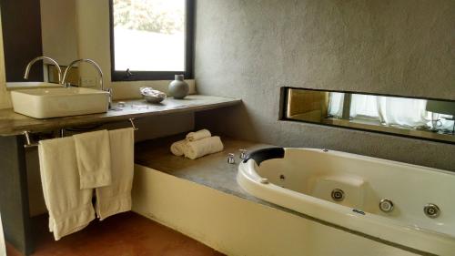 a bathroom with a large tub and a sink at Hotel Boutique La Milagrosa in Tepoztlán