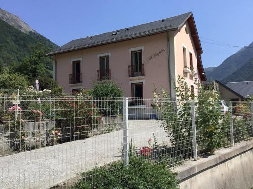 a house behind a fence with flowers in front of it at Villa Eth Mayouret in Cauterets