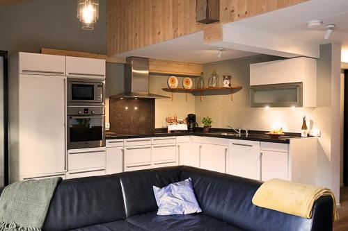 a living room with a black couch in a kitchen at De Spaanse Ruiter in Leusden