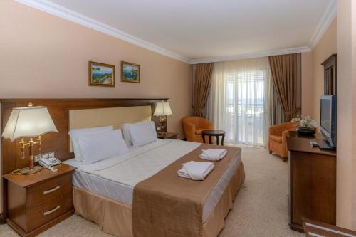 a hotel room with a large bed and a television at Latanya Park Resort in Yaliciftlik