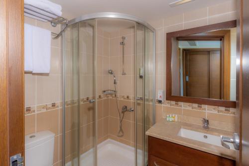 a bathroom with a shower and a tub and a sink at Latanya Park Resort in Yaliciftlik