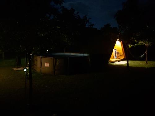 a tent in the dark with a light in the background at GLAMPING HIŠKe PETRIN in Tolmin
