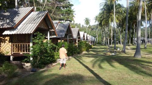 a person walking in front of a row of houses at Green Chilli Bungalows in Ko Lanta